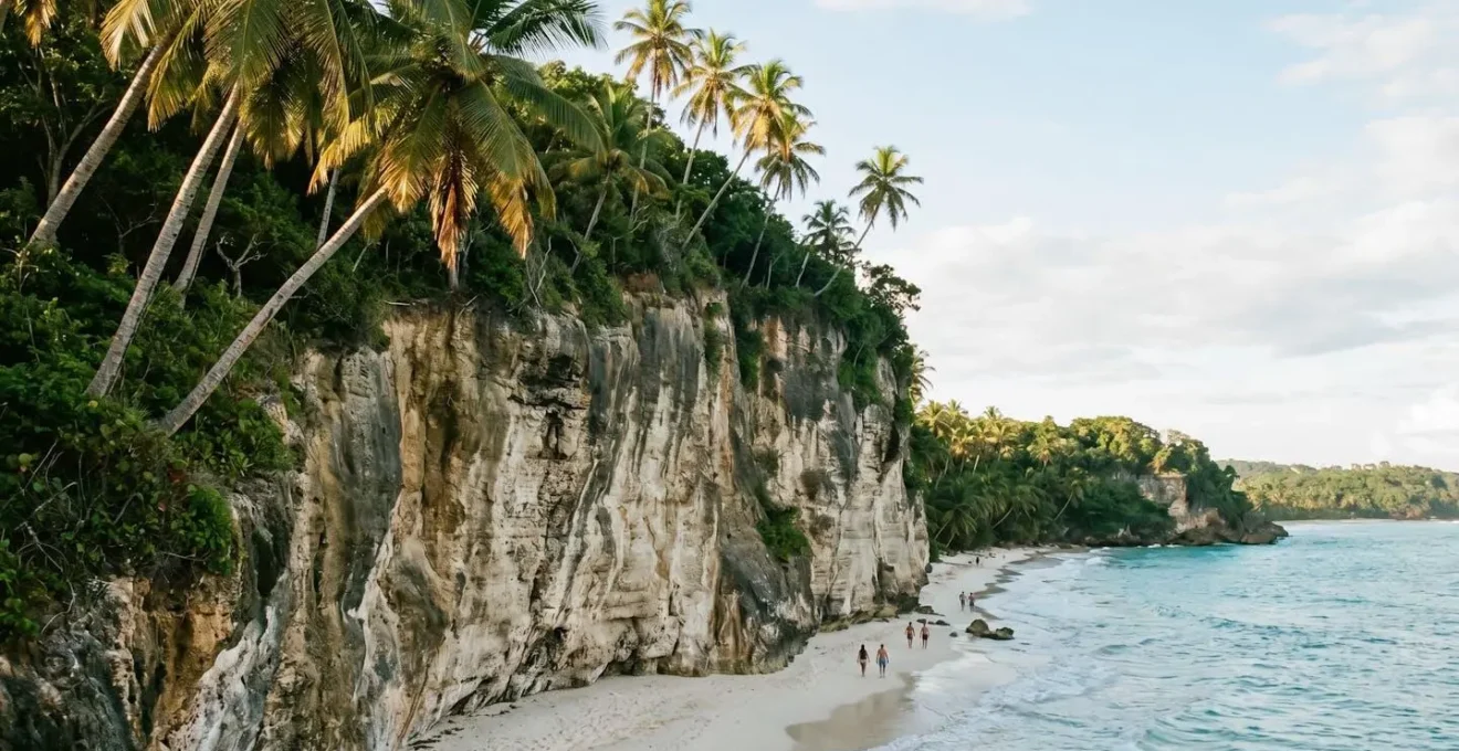 Towering limestone cliff face of Playa Frontón meeting turquoise Caribbean waters
