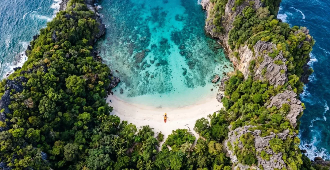 Aerial view of secret beach cove surrounded by dense jungle and limestone cliffs