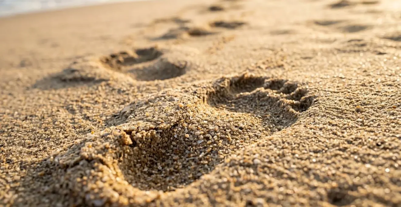 Extreme close-up of footprint impressions in rippled sand showing texture details