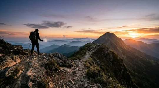 Hiker approaching Pico Duarte summit at dawn with panoramic Caribbean mountain views