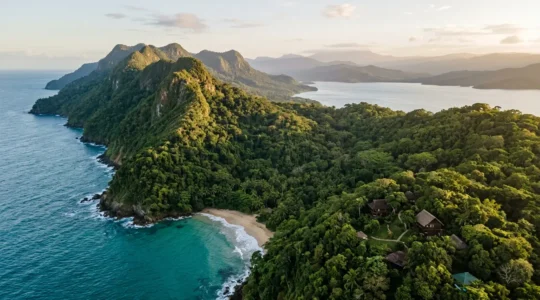 Aerial view of a secluded jungle lodge nestled between turquoise Samaná Bay and lush tropical rainforest