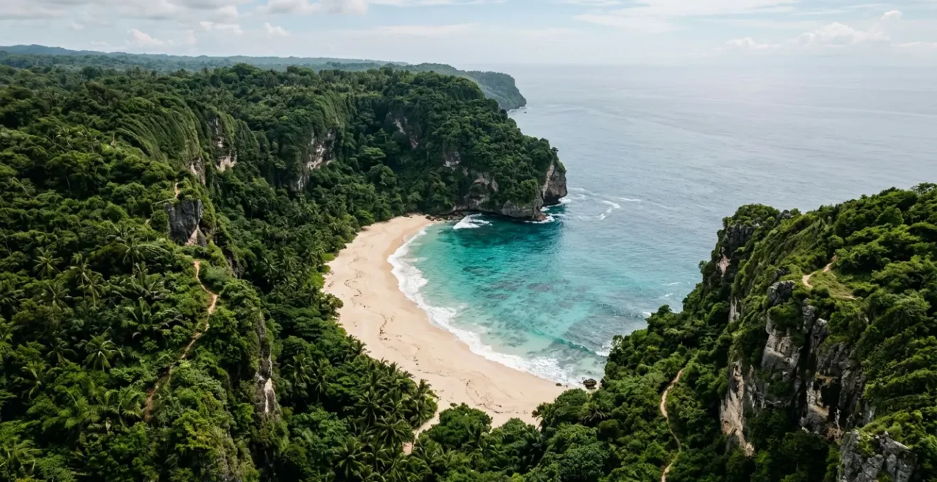 Aerial view of a secluded cove with turquoise waters surrounded by rugged cliffs