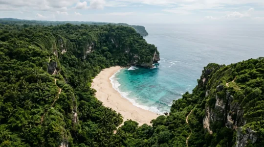 Aerial view of a secluded cove with turquoise waters surrounded by rugged cliffs