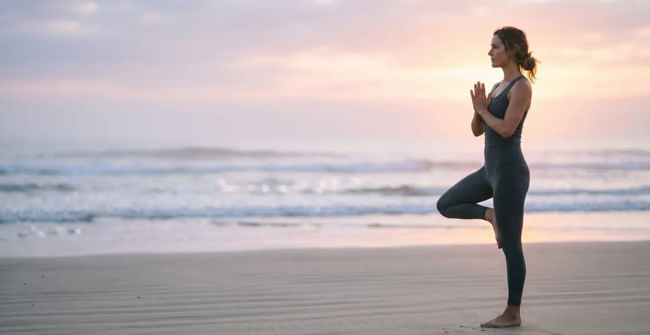 Solitary yoga practitioner in peaceful pose on deserted beach at dawn with misty atmosphere