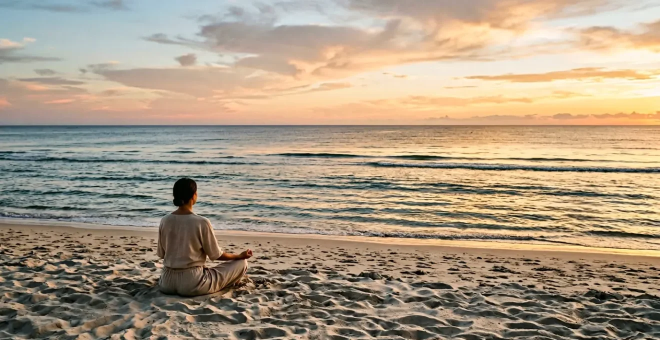 A traveler practicing morning meditation on a peaceful beach at sunrise with gentle waves