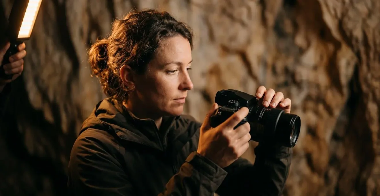 Professional photographer using specialized low-light equipment in cave setting